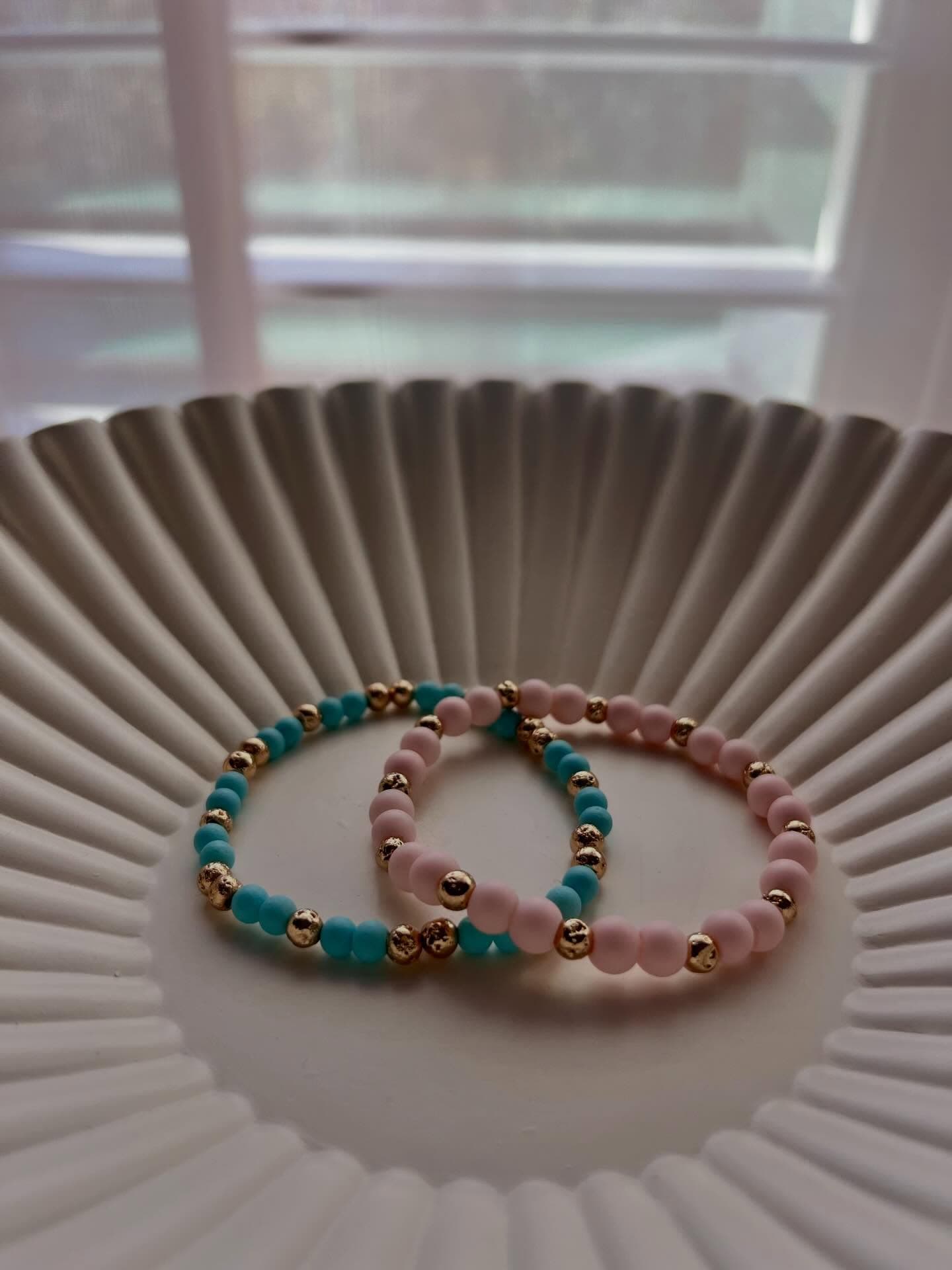 Sol Project: two bracelets sitting on a white plate with a window in the background.